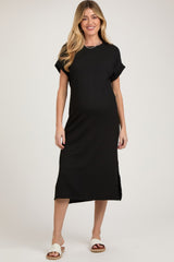 woman wearing a black short sleeve maternity dress with side slits and a relaxed fit, highlighting her baby bump