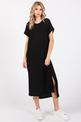 woman wearing a black oversized t-shirt dress with side slits and white sneakers