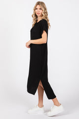 woman wearing a black ribbed midi dress with short sleeves and a side slit, paired with white sneakers