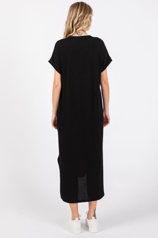 woman wearing a black maxi dress with short sleeves and side slits, viewed from the back