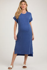 woman wearing a blue striped maternity dress with short sleeves and side slits, showcasing her baby bump