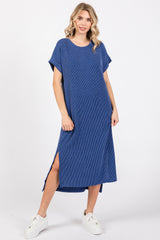 woman wearing a navy blue striped maxi dress with short sleeves and side slits, paired with white sneakers
