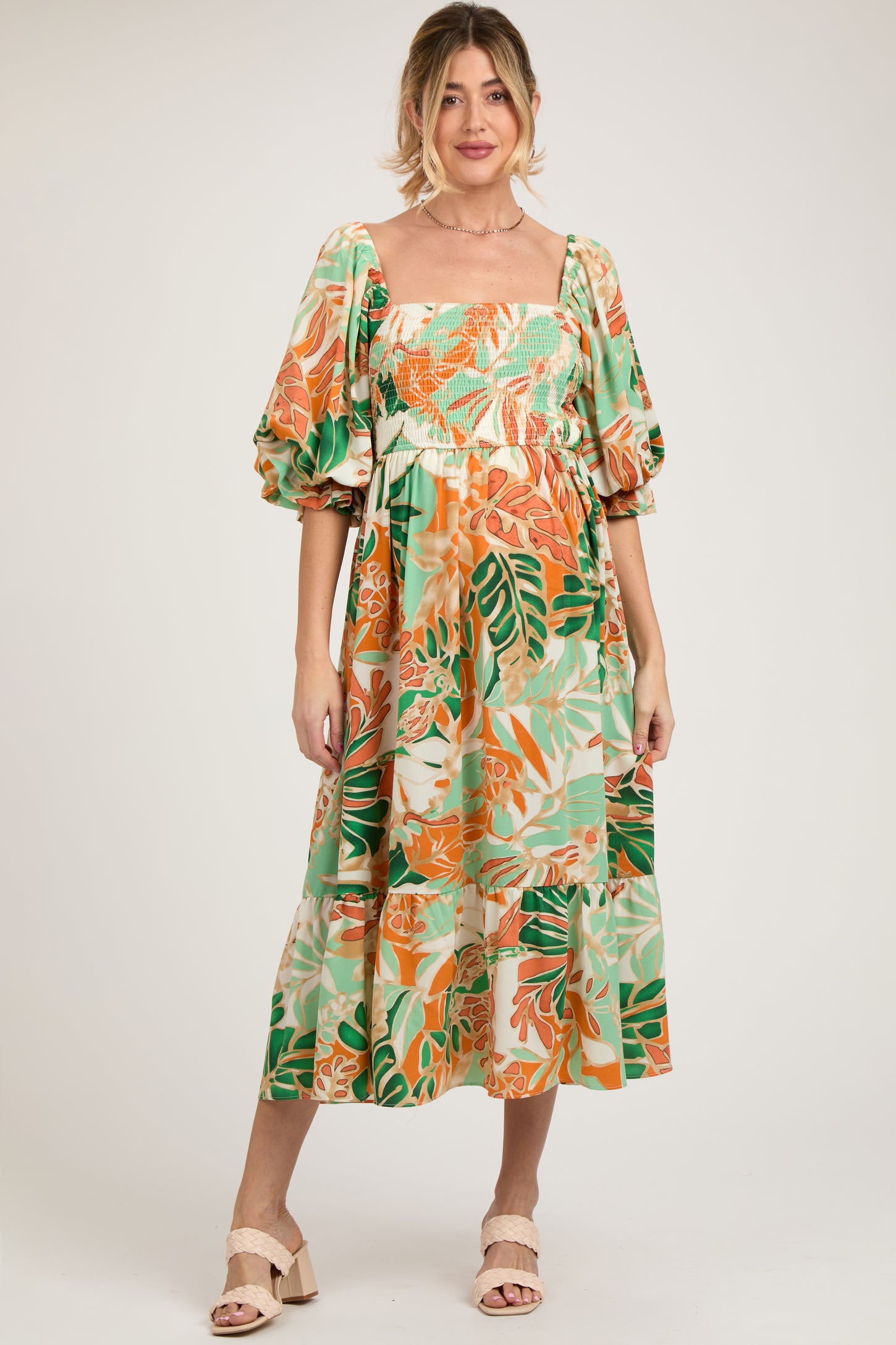 woman wearing a floral print maternity dress with puff sleeves and a square neckline