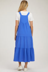 woman wearing a blue tiered maternity dress with adjustable straps and a flowing skirt