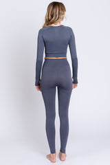 woman wearing a gray long sleeve crop top and matching high-waisted leggings, viewed from the back