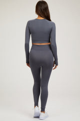 woman wearing a gray long sleeve crop top and matching leggings, styled for maternity wear