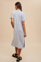 woman wearing a light blue short sleeve midi dress with a relaxed fit and side slits, viewed from the back
