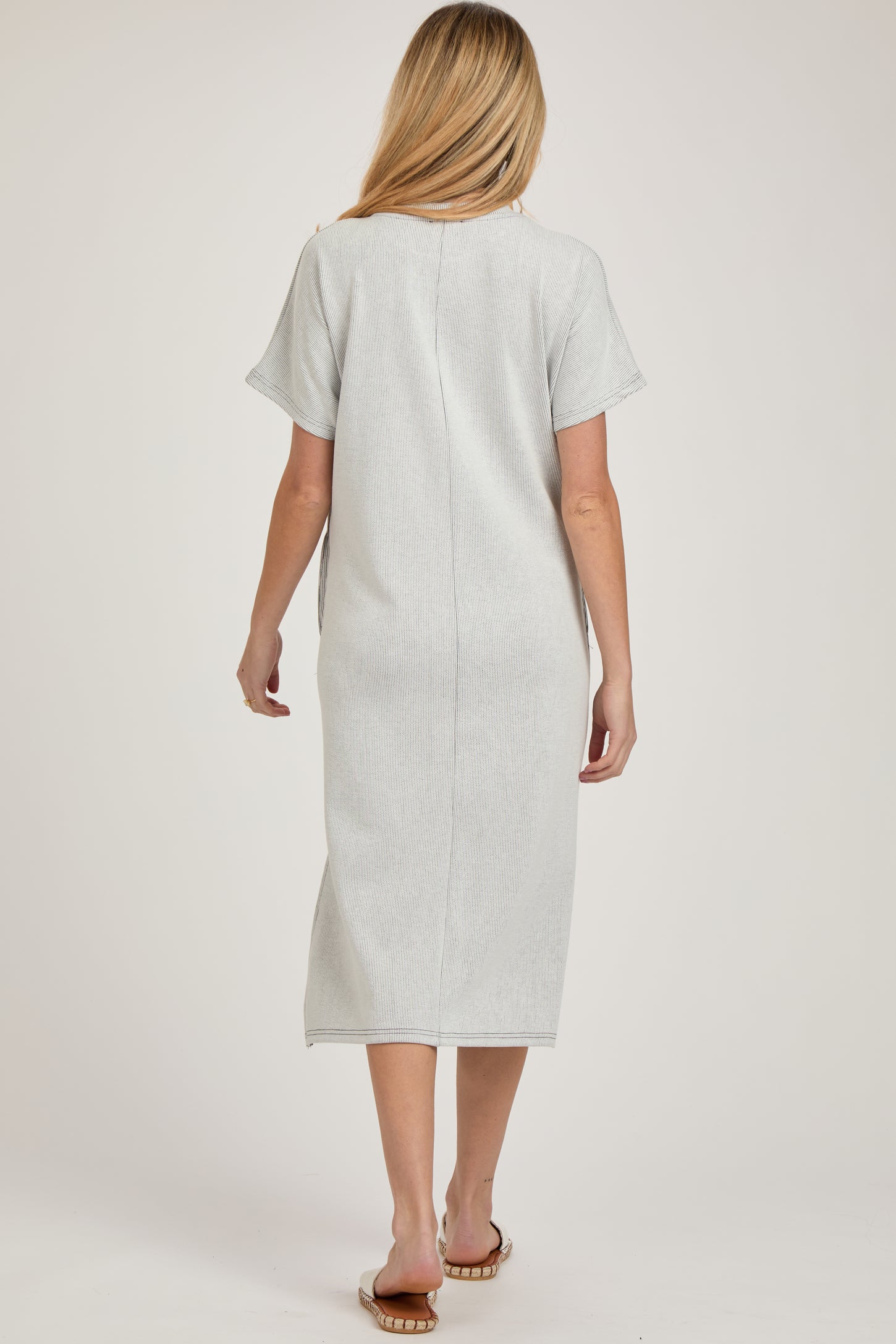 woman wearing a light gray maternity midi dress with short sleeves and a relaxed fit, view from the back