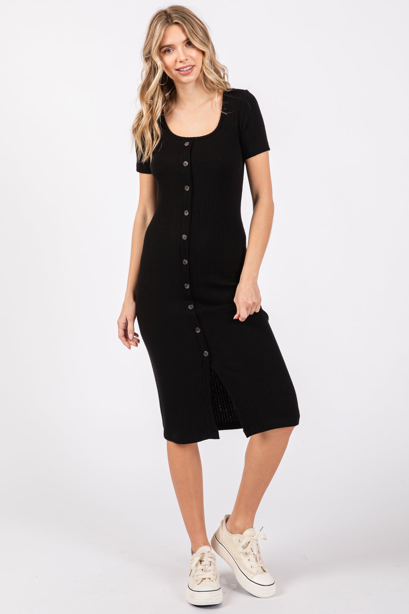 woman wearing a black ribbed button-front midi dress with short sleeves and a front slit, styled with white sneakers