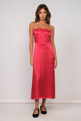 woman wearing a strapless hot pink satin midi dress with a fitted bodice and a flared skirt
