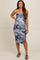 woman wearing a blue camo print maternity dress with side ruching and a slit, showing her baby bump