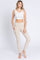 woman wearing a white crop top and light beige high-waisted leggings with pockets