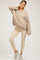 woman wearing a taupe oversized maternity sweater and beige ribbed maternity leggings