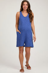 woman wearing a blue sleeveless maternity romper with pockets and a relaxed fit