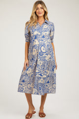 woman wearing a blue and cream patterned maternity dress with short puff sleeves and a midi length