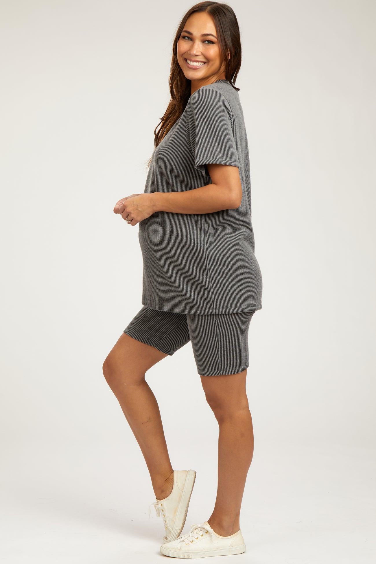 woman wearing a gray ribbed maternity short set with a visible baby bump