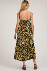 woman wearing a brown floral midi maternity dress with adjustable straps, showing a relaxed fit and tiered design
