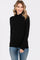 woman wearing a black long sleeve turtleneck sweater paired with light blue jeans