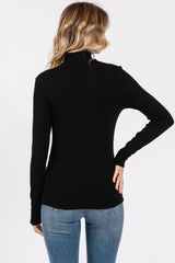 woman wearing a black long sleeve turtleneck top with a fitted style and back view, paired with light blue jeans