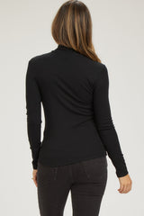 woman wearing a black long sleeve maternity top, showing the back view with a fitted style