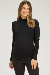 woman wearing a black long sleeve maternity top and smiling with her baby bump visible