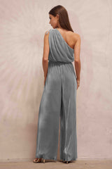woman wearing a silver one-shoulder jumpsuit with pleated detailing and a wide-leg style