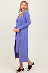 woman wearing a lavender ribbed long cardigan over a matching spaghetti strap dress and black slide sandals