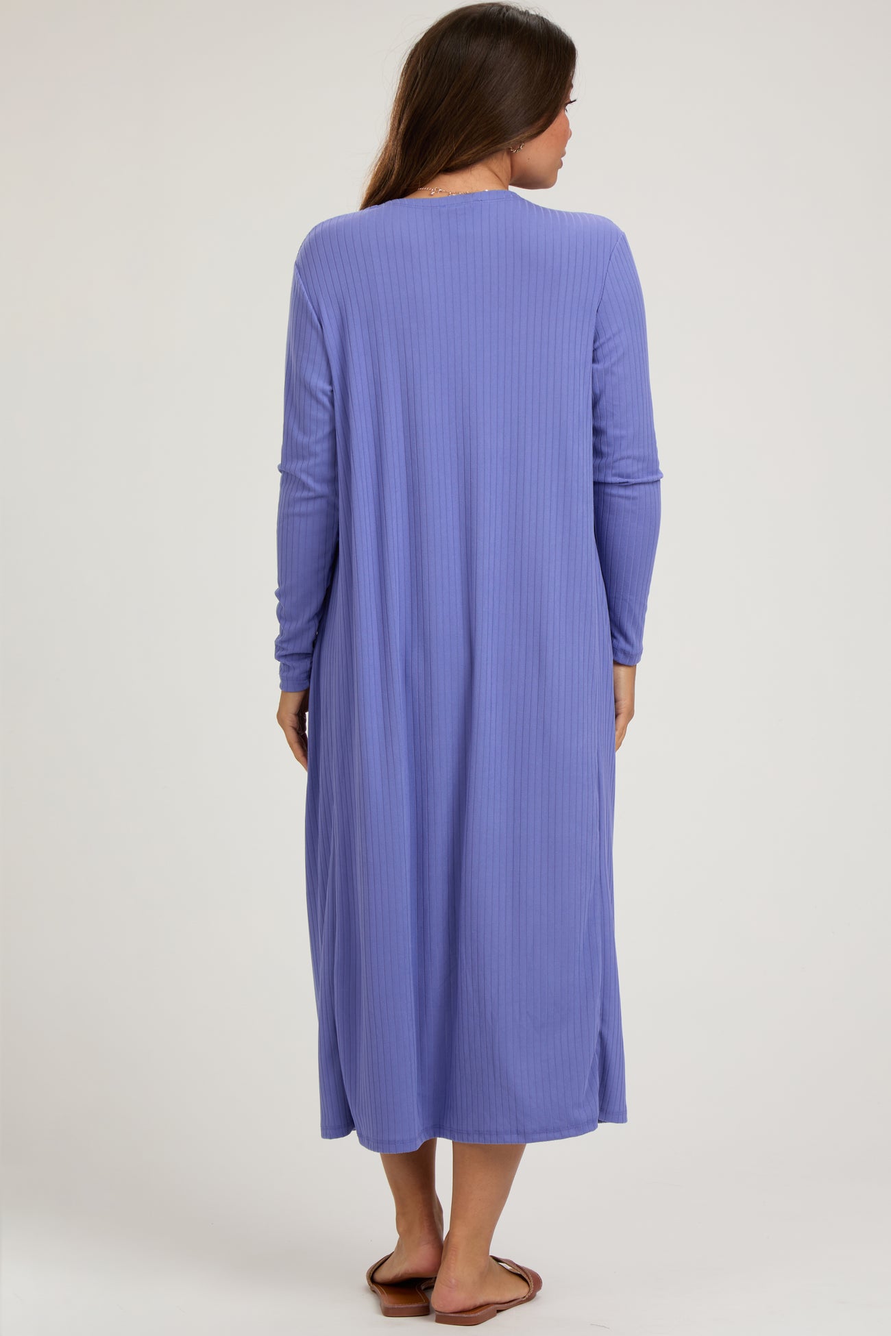 woman wearing a long sleeve purple maternity dress with a relaxed fit and side slits, showing a baby bump