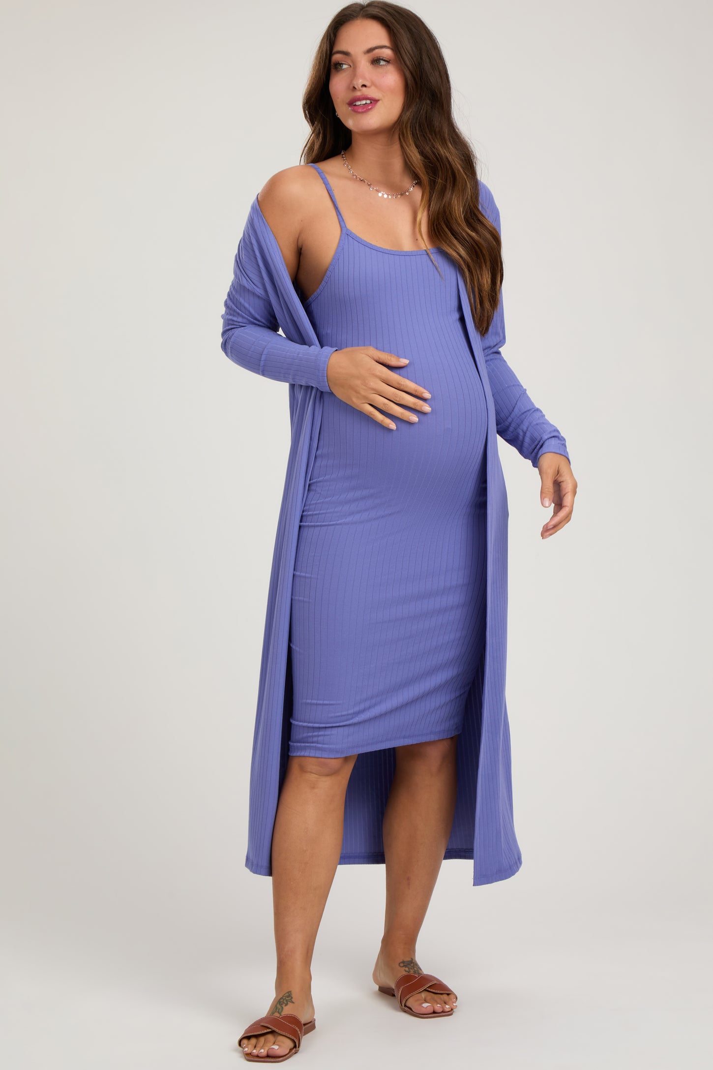 woman wearing a purple ribbed maternity dress with a long cardigan and showing her baby bump