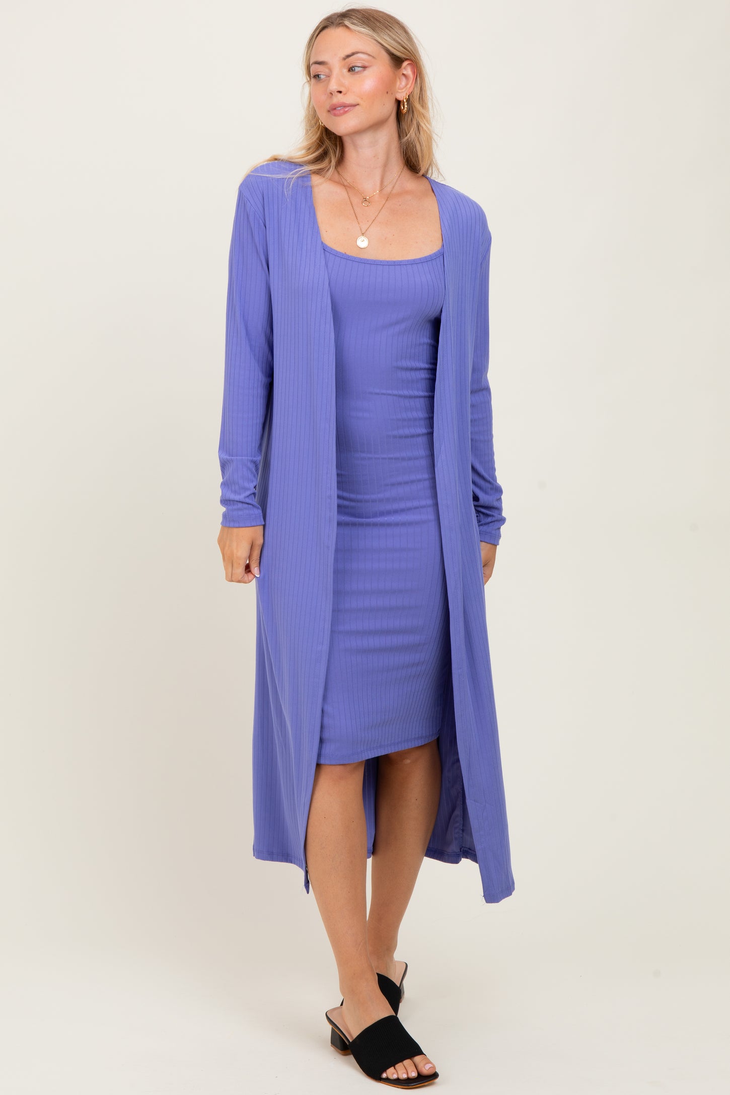 woman wearing a purple ribbed maxi cardigan over a matching fitted dress and black slide sandals