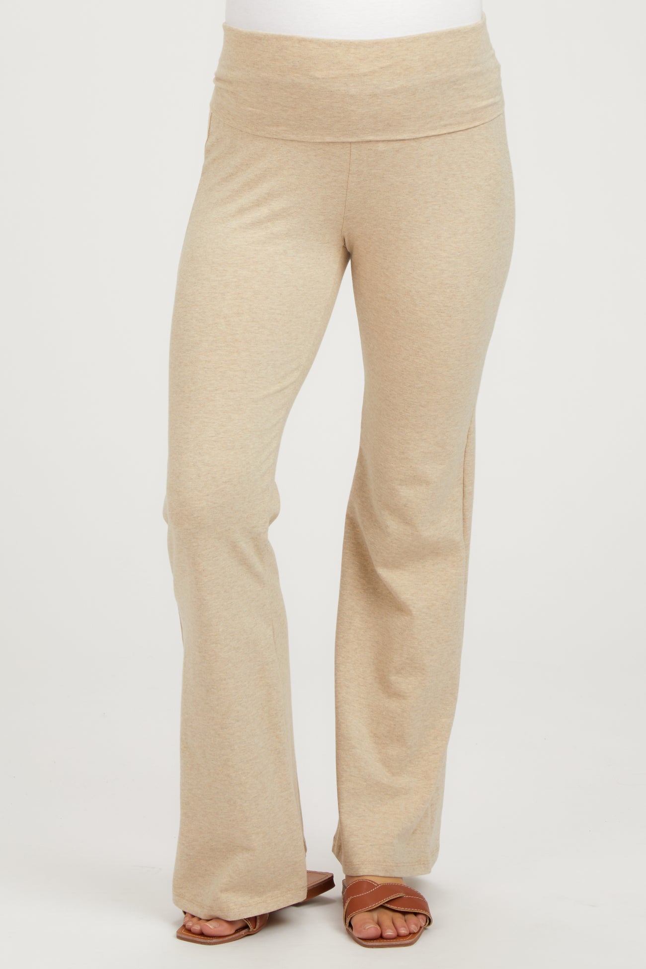 woman wearing beige maternity yoga pants with a wide waistband and flared legs