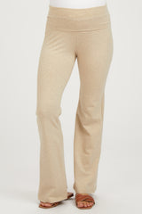 woman wearing beige maternity yoga pants with a wide waistband and flared legs