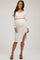 woman wearing a white ribbed maternity two-piece set with long sleeves and a side slit skirt, showcasing her baby bump