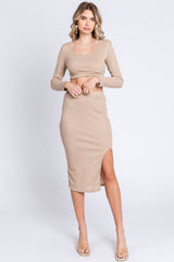woman wearing a beige long sleeve crop top and matching midi skirt with a side slit
