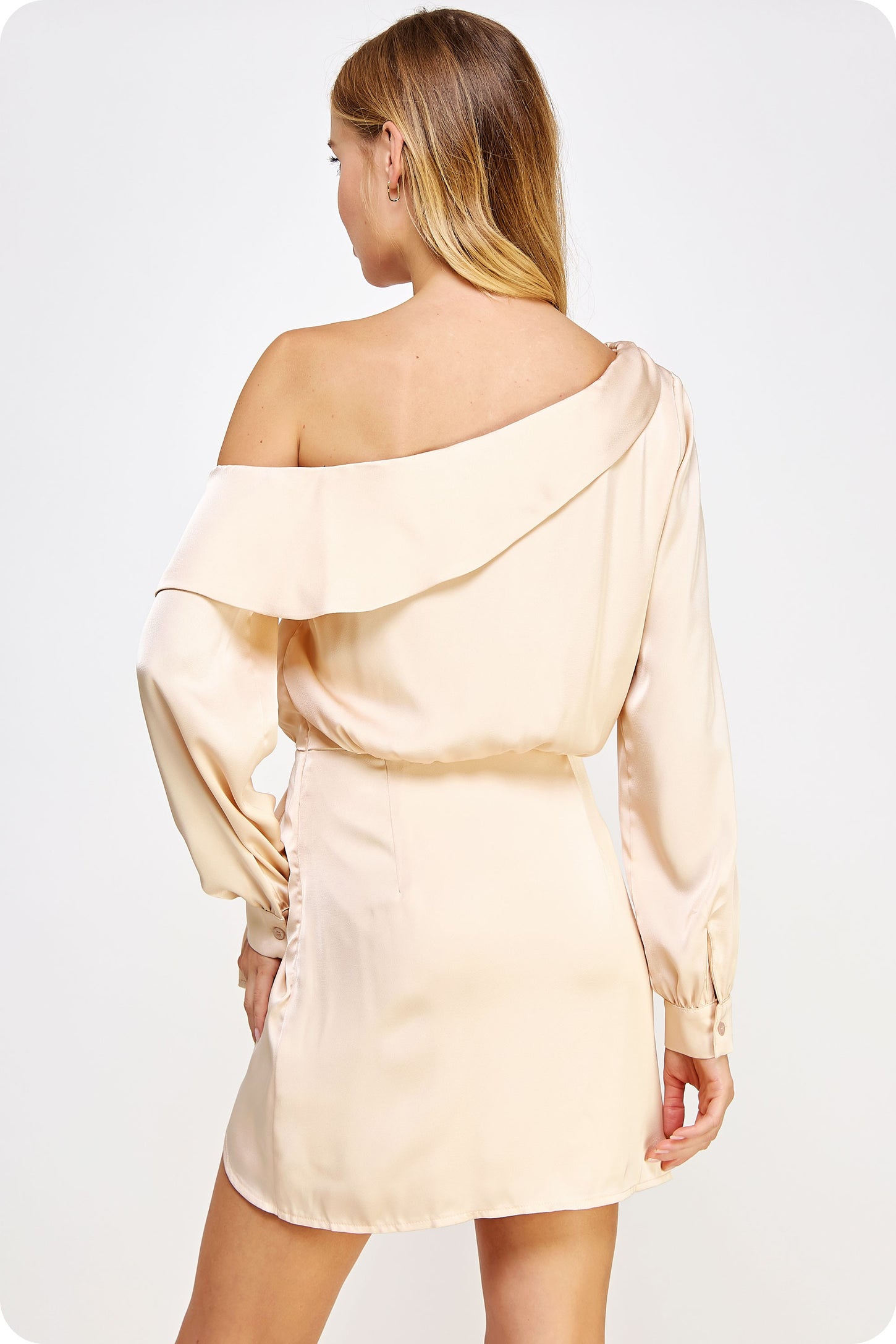 woman wearing a light peach off-the-shoulder mini dress with long sleeves and ruching detail on the side