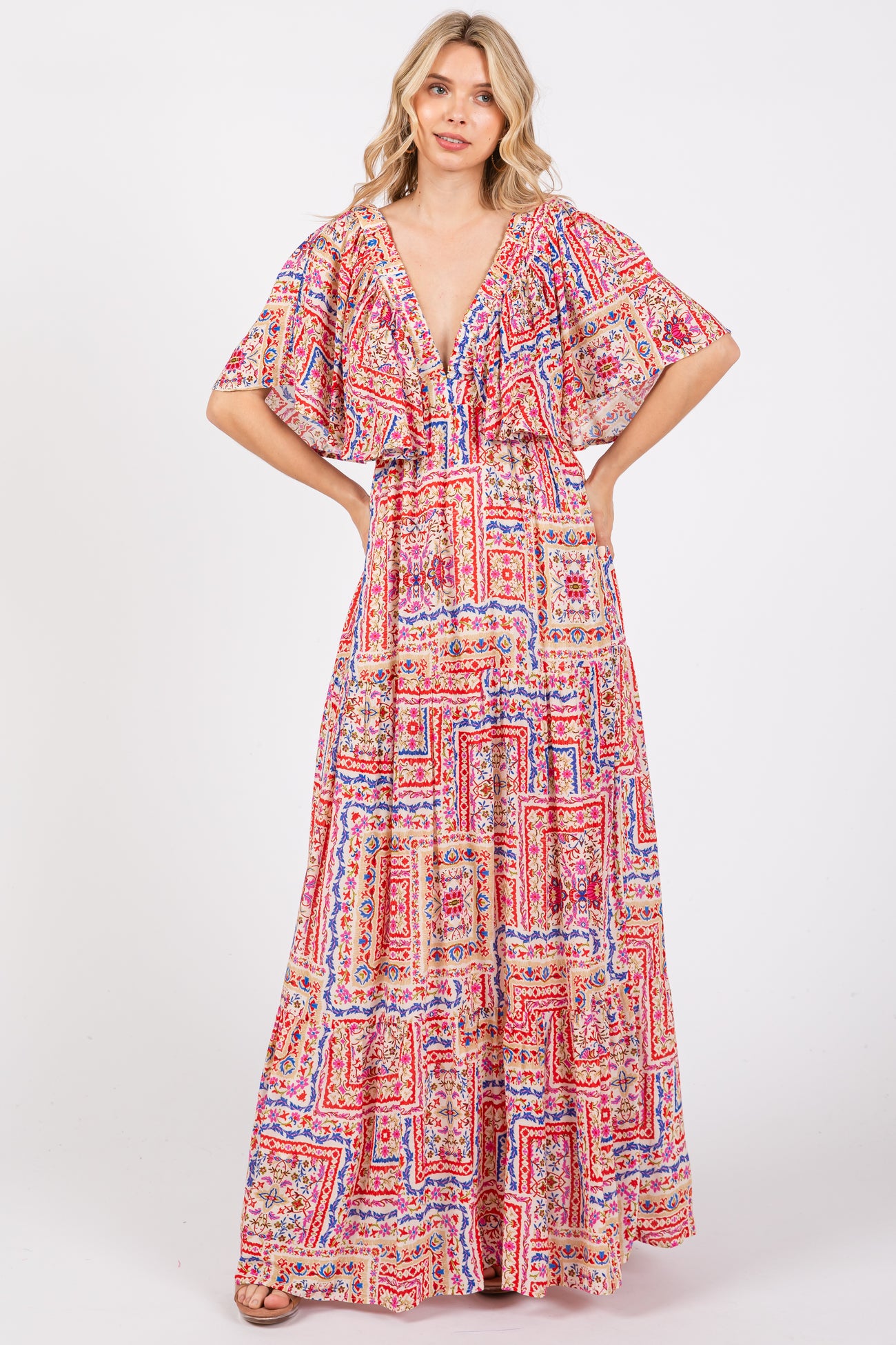 woman wearing a colorful pattern maxi dress with a deep v-neckline and flutter sleeves