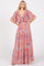 woman wearing a colorful pattern maxi dress with a deep v-neckline and flutter sleeves