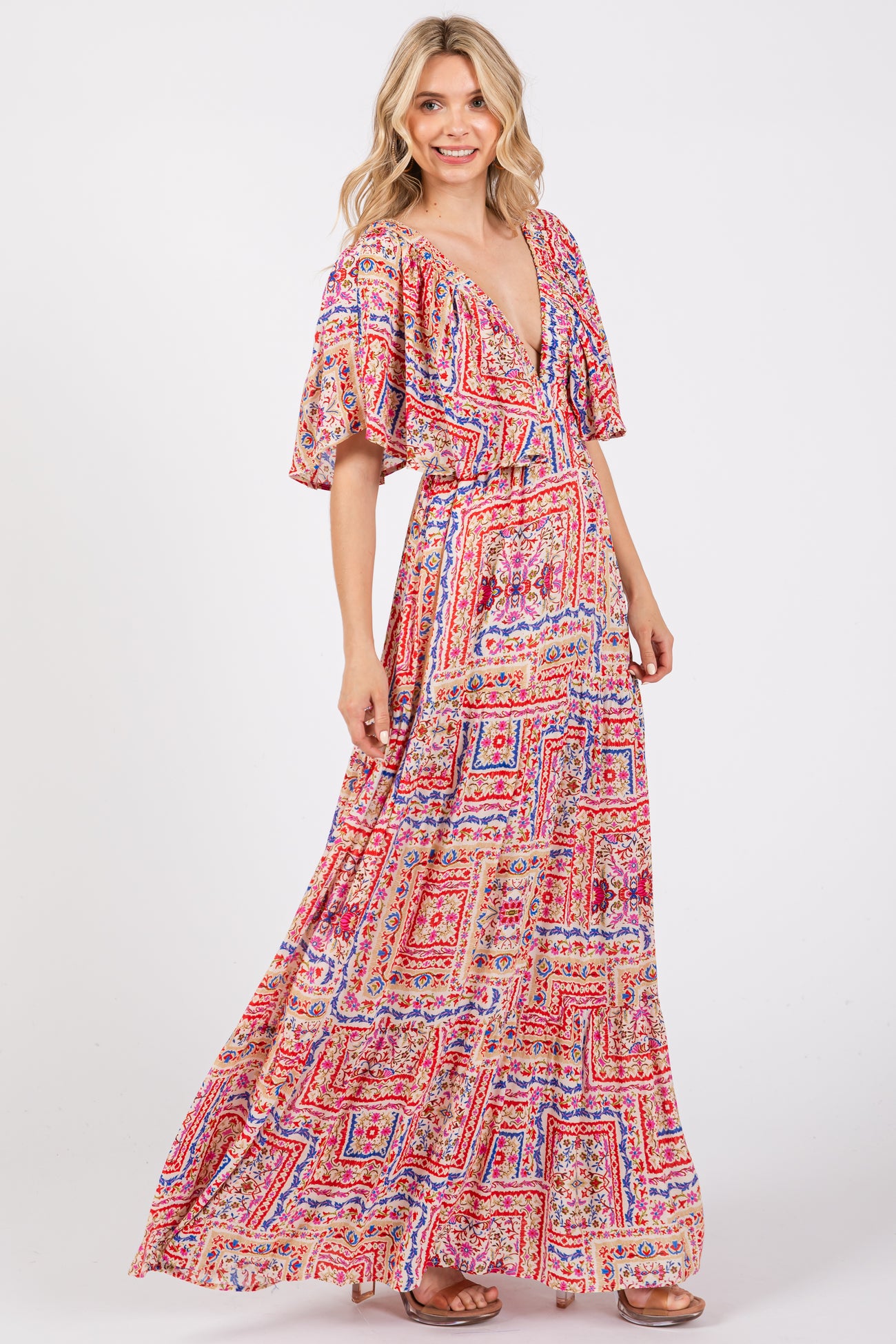 woman wearing a colorful patterned maxi dress with a deep v-neck and flutter sleeves