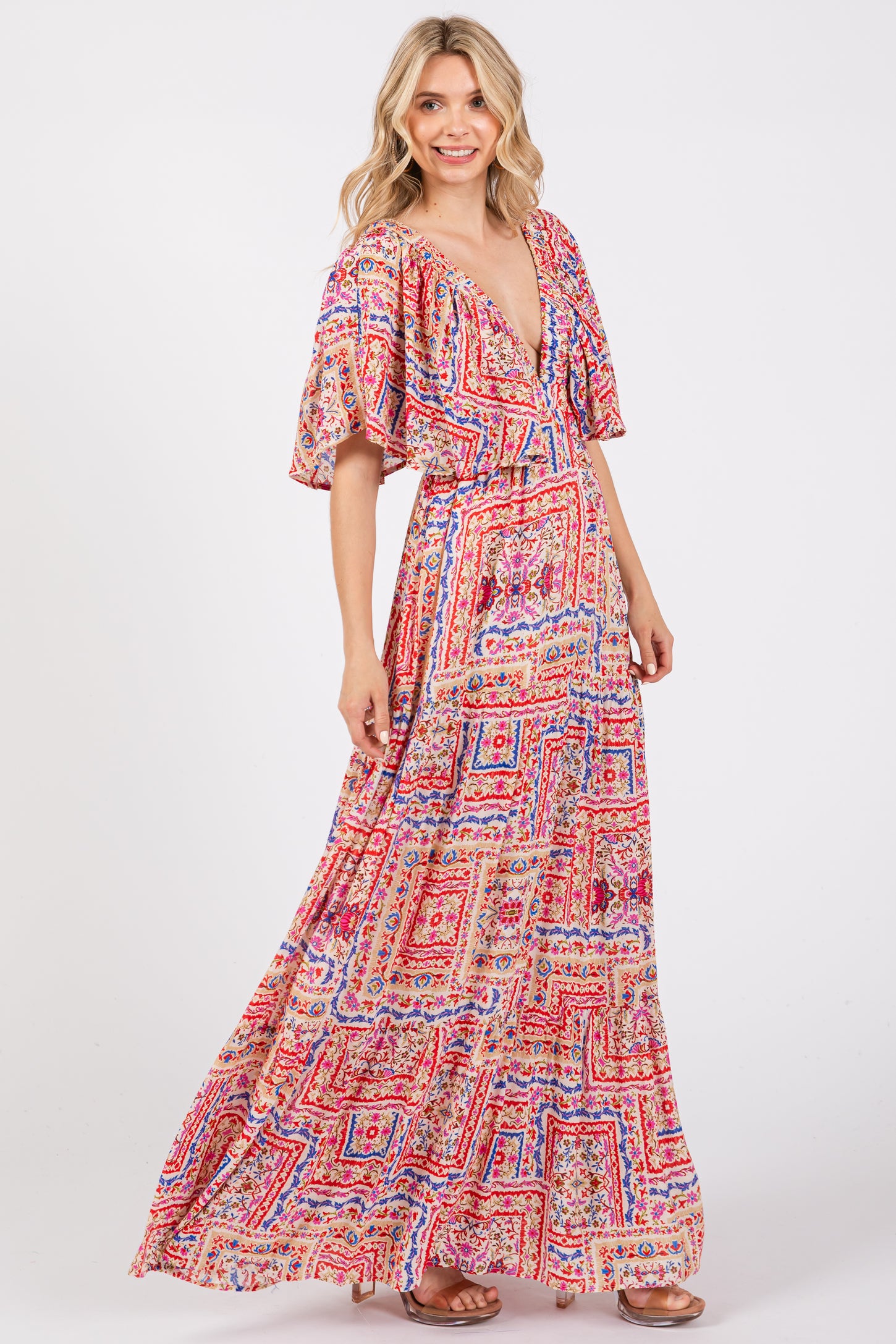 woman wearing a colorful patterned maxi dress with a deep v-neck and flutter sleeves