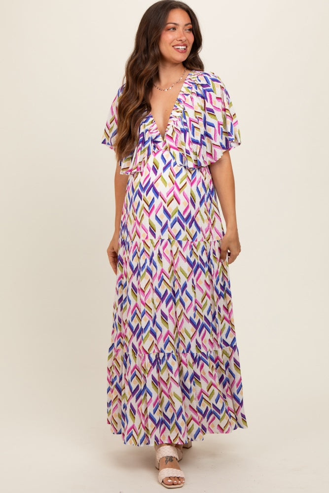 woman wearing a multicolored patterned maternity maxi dress with flutter sleeves and a deep v-neckline