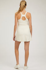 woman wearing a white maternity dress with a racerback design, showing the back and a relaxed fit