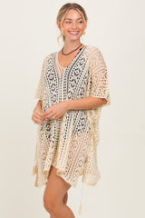 woman wearing a beige crochet cover-up with a v-neck and side ties