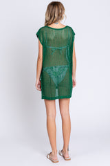 woman wearing a green open-knit cover-up with short sleeves, shown from the back