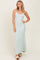 woman wearing a light green ribbed maxi dress with spaghetti straps and a side slit