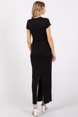 woman wearing a black short sleeve maxi dress with a back slit detail