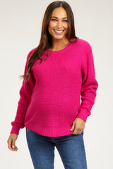 woman wearing a hot pink maternity sweater with a relaxed fit and long sleeves, showing her baby bump