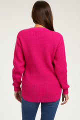 woman wearing a bright pink knitted maternity sweater, showing a relaxed fit and long sleeves from the back