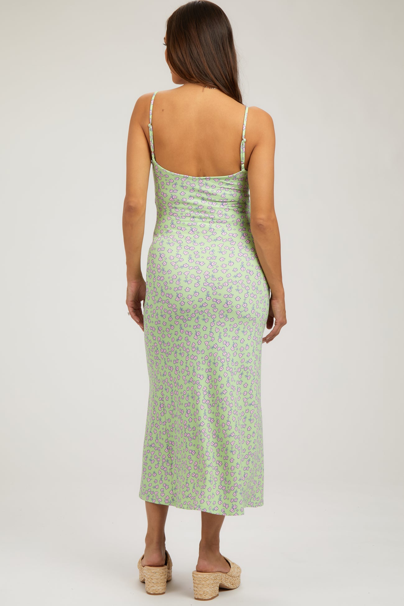 woman wearing a green leopard print maternity midi dress with spaghetti straps and a fitted silhouette