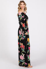 woman wearing a black off-the-shoulder maxi dress with colorful floral prints and long sleeves