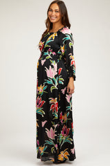 woman wearing a black floral print maternity maxi dress with long sleeves and a fitted waist, showing a baby bump